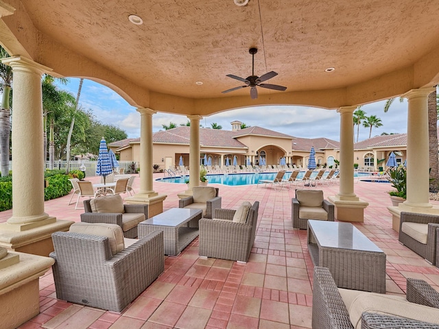 view of patio / terrace with ceiling fan, a community pool, and an outdoor living space