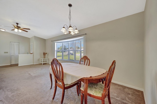 dining room with lofted ceiling, ceiling fan with notable chandelier, and carpet