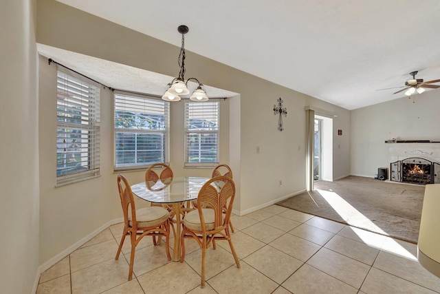 dining space with lofted ceiling, light carpet, and ceiling fan