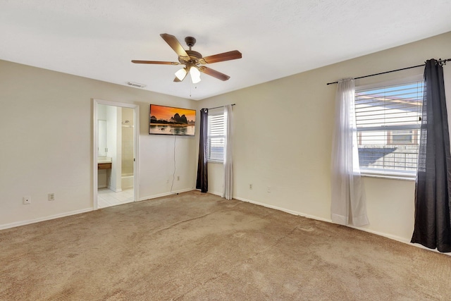 carpeted empty room with ceiling fan and a wealth of natural light