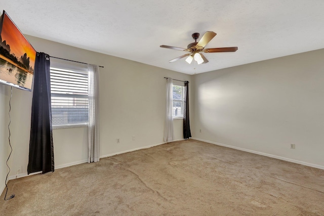 carpeted spare room with a textured ceiling and ceiling fan