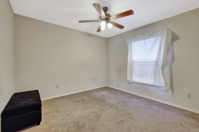 carpeted spare room featuring ceiling fan