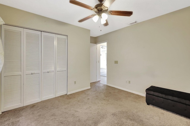 unfurnished bedroom featuring light carpet, ceiling fan, and a closet