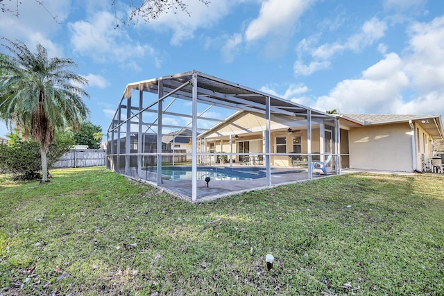 view of pool with ceiling fan, a yard, a lanai, and a patio area