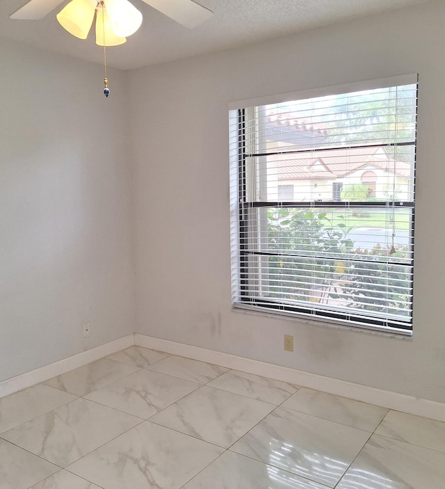 empty room with ceiling fan and a healthy amount of sunlight