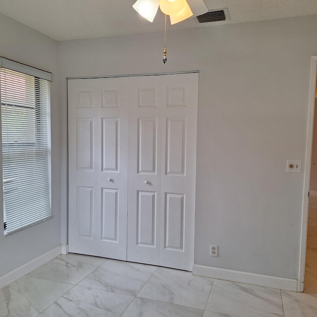 unfurnished bedroom featuring a closet and ceiling fan