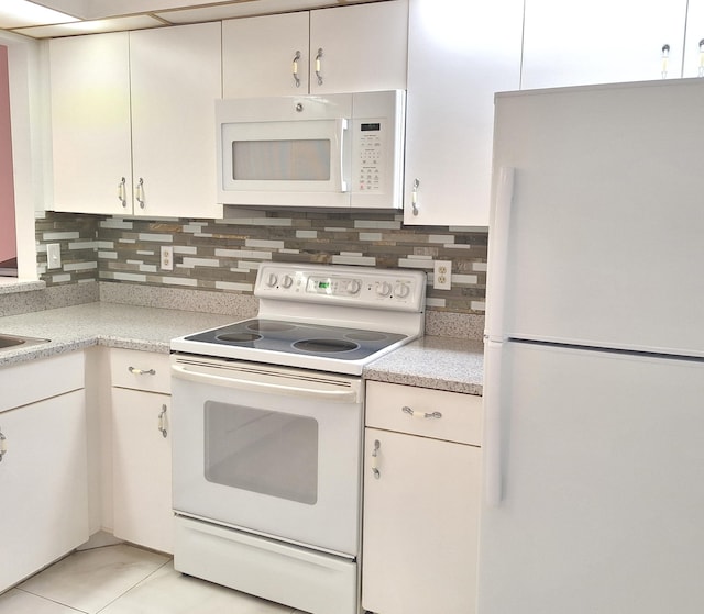 kitchen featuring light tile patterned floors, backsplash, and white appliances