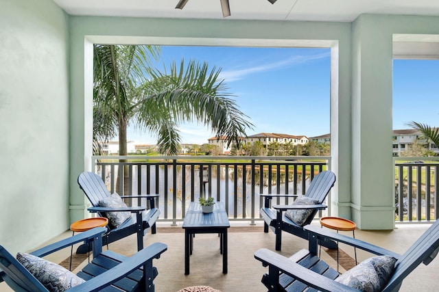 balcony featuring ceiling fan and a water view