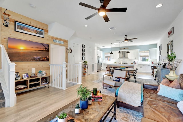 living room with wooden walls and light wood-type flooring