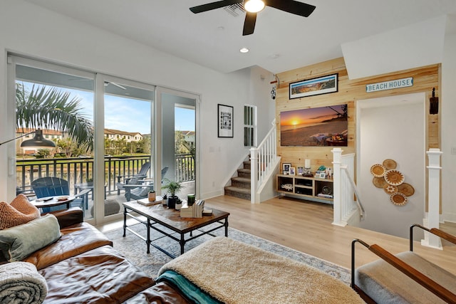 living room with light hardwood / wood-style floors and wood walls