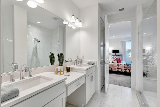 bathroom featuring tiled shower and vanity