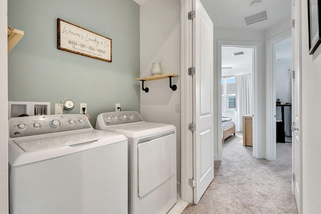 clothes washing area featuring separate washer and dryer and light carpet