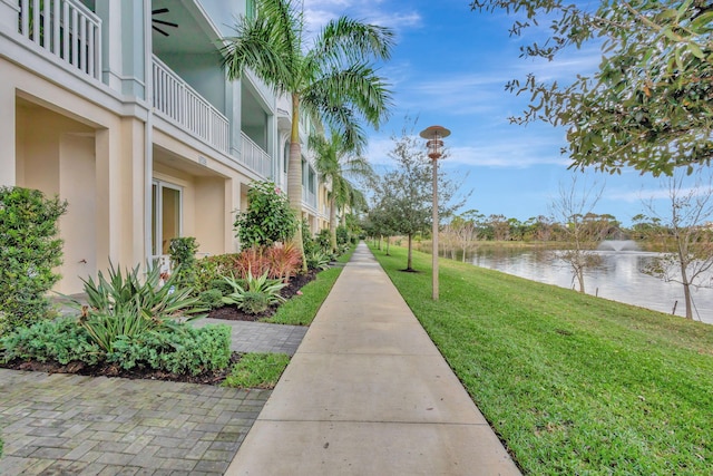 view of property's community with a water view and a yard