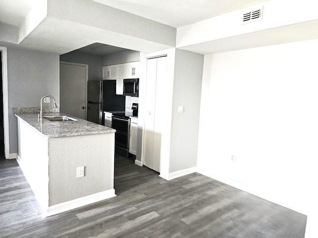 kitchen featuring sink, white cabinetry, range with electric cooktop, light stone counters, and kitchen peninsula