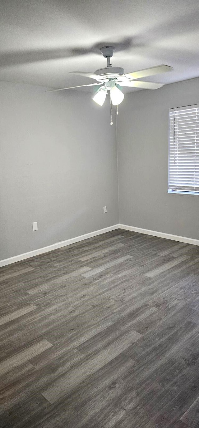 empty room with dark wood-type flooring and ceiling fan