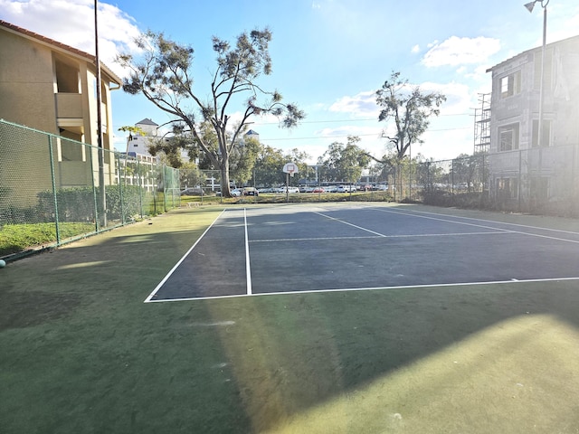 view of tennis court with basketball hoop