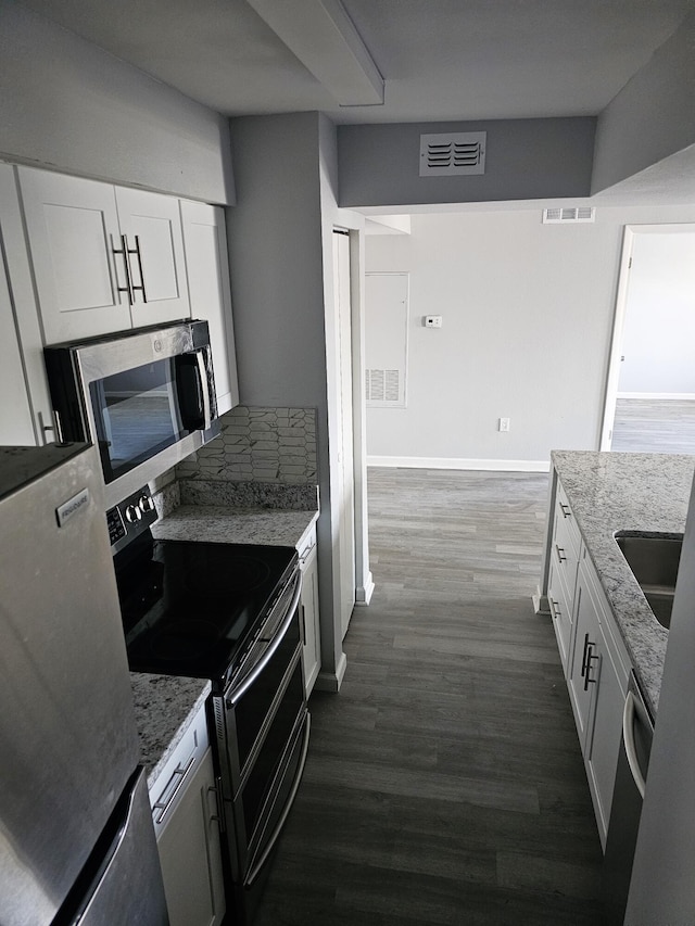 kitchen featuring stainless steel appliances, light stone countertops, sink, and white cabinets