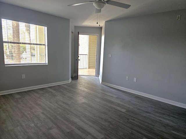 empty room with ceiling fan and dark hardwood / wood-style flooring