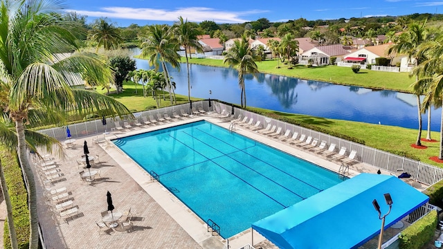 view of swimming pool featuring a water view, a lawn, and a patio area