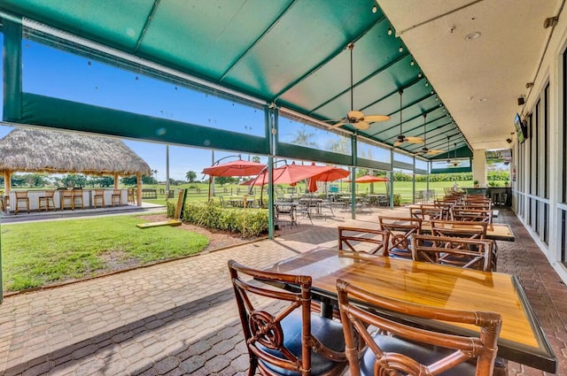 view of patio / terrace featuring a gazebo, ceiling fan, and exterior bar