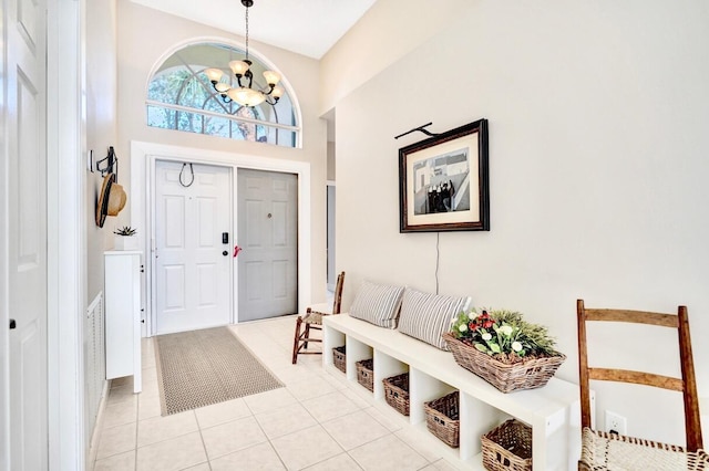 tiled entrance foyer with a notable chandelier