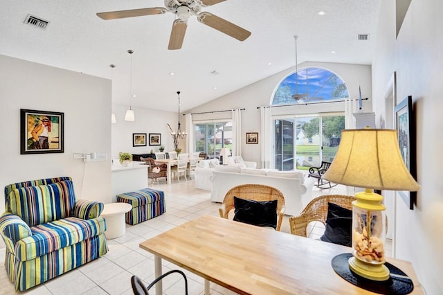 tiled living room with lofted ceiling, ceiling fan with notable chandelier, and a textured ceiling