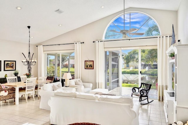 living room with ceiling fan with notable chandelier, plenty of natural light, light tile patterned floors, and a textured ceiling