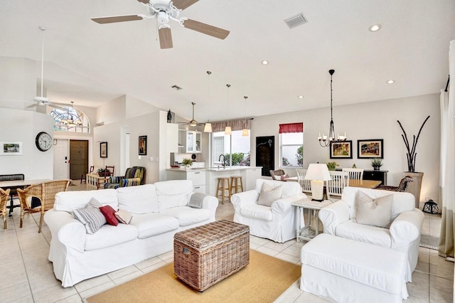 living room with ceiling fan with notable chandelier, lofted ceiling, sink, and light tile patterned floors