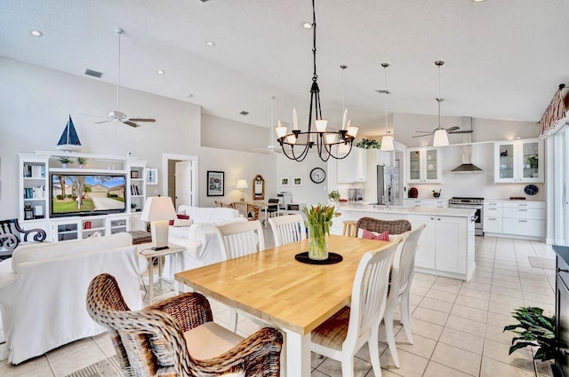 tiled dining area with ceiling fan with notable chandelier and high vaulted ceiling