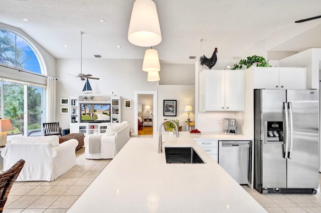 kitchen with light tile patterned flooring, sink, pendant lighting, stainless steel appliances, and white cabinets