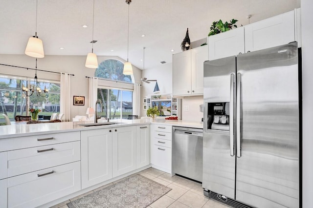 kitchen featuring sink, light tile patterned floors, pendant lighting, stainless steel appliances, and white cabinets