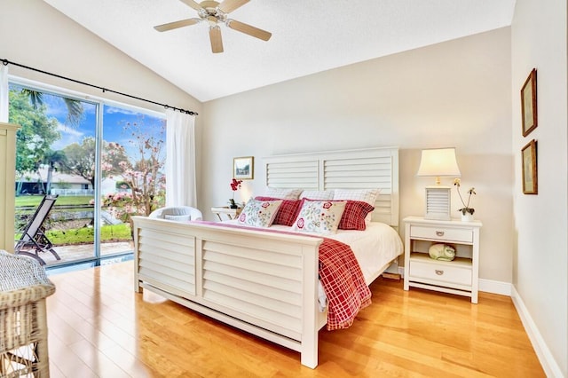 bedroom with hardwood / wood-style flooring, access to outside, ceiling fan, and vaulted ceiling