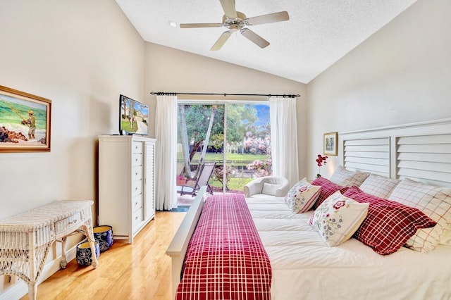 bedroom featuring lofted ceiling, ceiling fan, access to exterior, hardwood / wood-style floors, and a textured ceiling