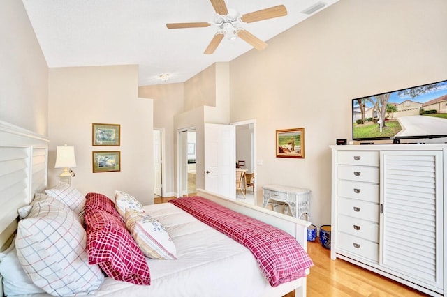 bedroom featuring high vaulted ceiling, ceiling fan, and light wood-type flooring