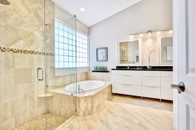 bathroom with tile patterned floors, lofted ceiling, independent shower and bath, and vanity