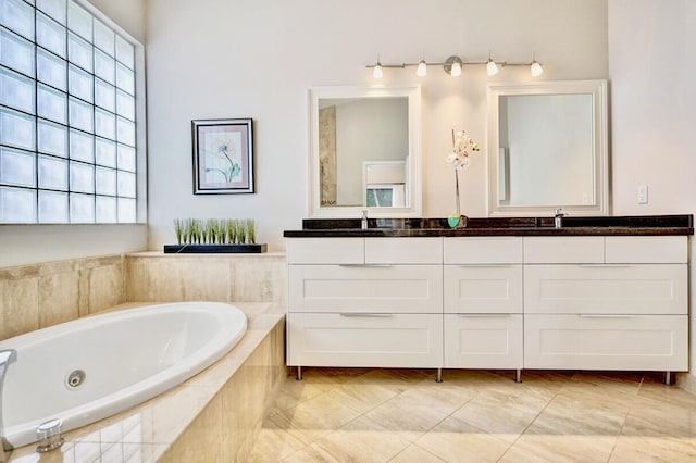 bathroom with a relaxing tiled tub, tile patterned floors, and vanity