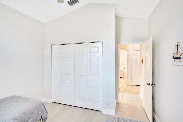 bedroom featuring lofted ceiling, a closet, and light hardwood / wood-style flooring