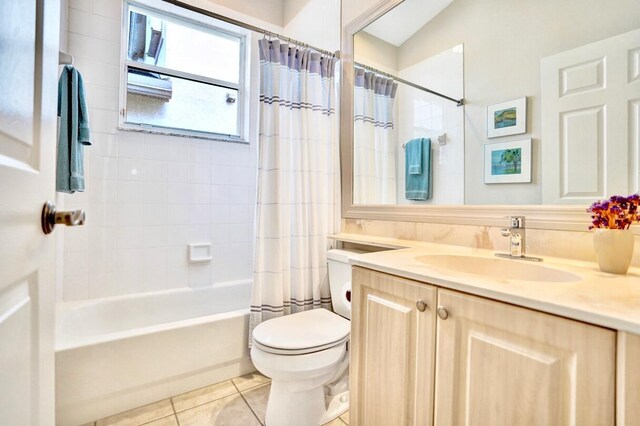 full bathroom featuring vanity, toilet, tile patterned flooring, and shower / bath combo with shower curtain