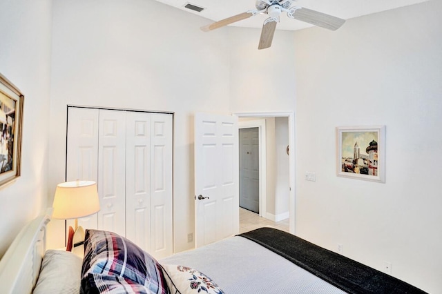 bedroom featuring ceiling fan, a closet, and a high ceiling