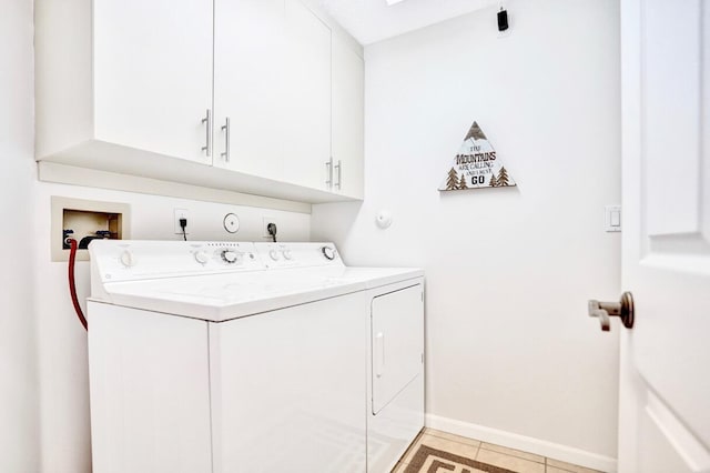 clothes washing area with cabinets and washing machine and clothes dryer