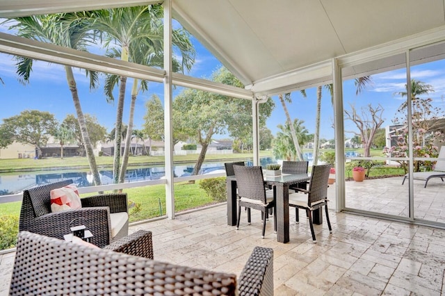 sunroom featuring lofted ceiling, a healthy amount of sunlight, and a water view