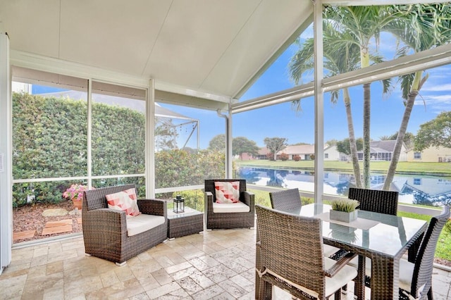 sunroom / solarium featuring a water view and lofted ceiling