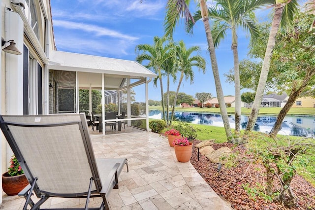 view of patio with a sunroom and a water view