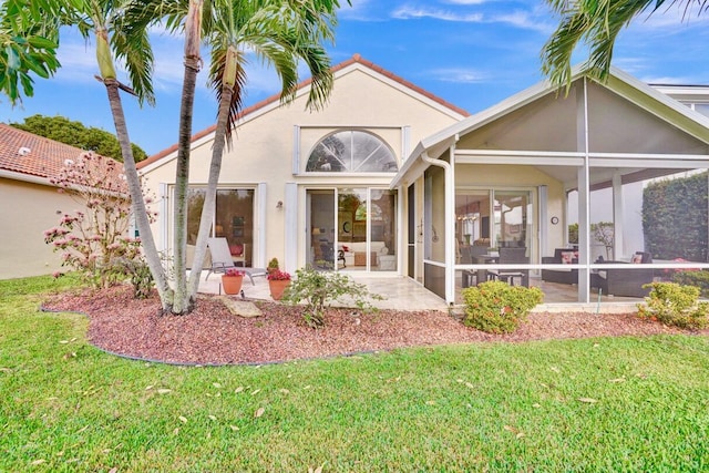 back of house with a patio, a sunroom, and a lawn