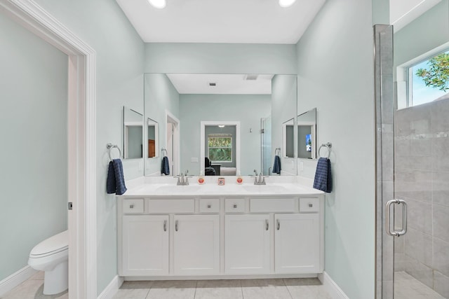 bathroom with a shower with door, vanity, tile patterned floors, and toilet