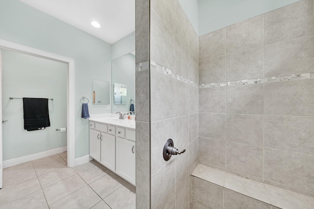 bathroom featuring tiled shower, vanity, and tile patterned flooring