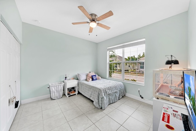 tiled bedroom with ceiling fan and a closet