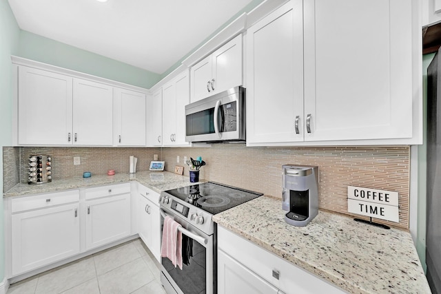 kitchen featuring white cabinetry, stainless steel appliances, light stone countertops, and tasteful backsplash