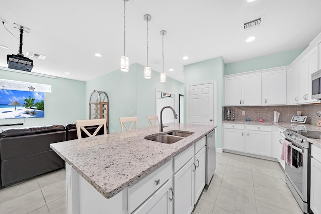 kitchen with sink, appliances with stainless steel finishes, an island with sink, white cabinets, and decorative backsplash