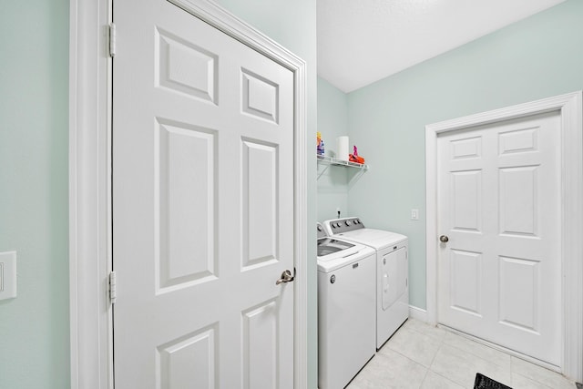 clothes washing area with light tile patterned floors and washer and dryer